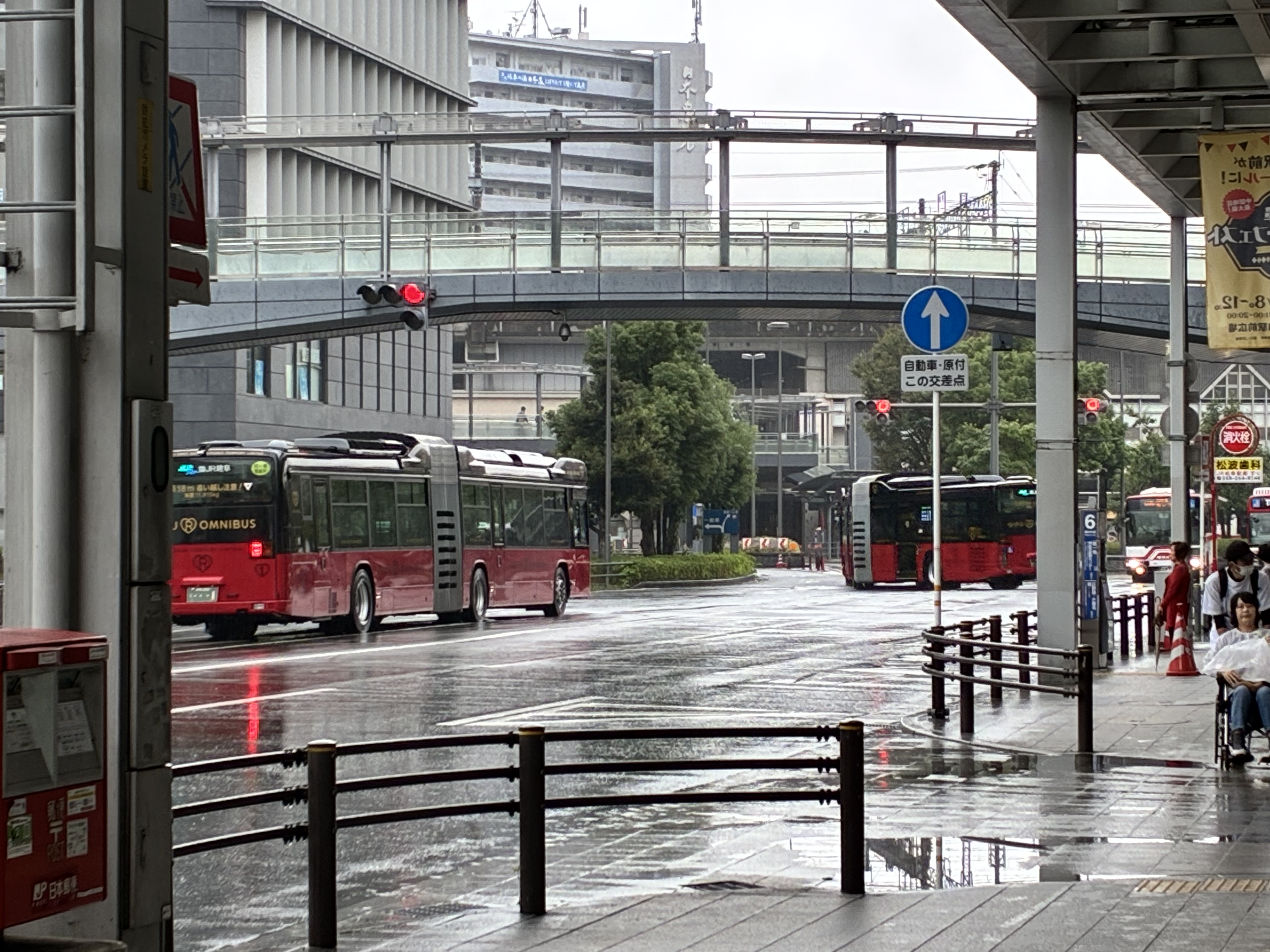 岐阜駅前の交差点にロングバスと雨の日の街並み